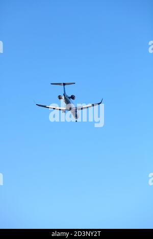 Rückansicht eines Landeflugzeugs gegen den klaren blauen Himmel. Stockfoto