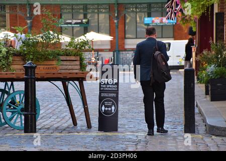 Ein Mann geht an einem Stop vorbei die Verbreitung von Coronavirus Straßenschild in Covent Garden, London, 2020. Um die Straßen und den Markt von Covent Garden herum wurden Schilder angebracht, um die soziale Distanzierung zu fördern. Stockfoto