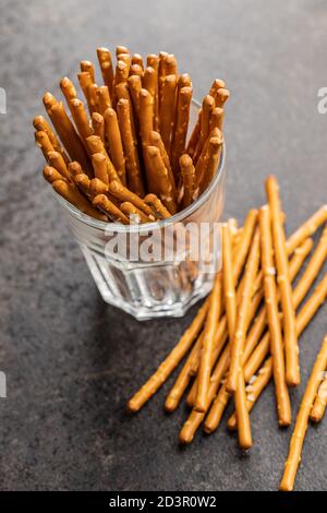 Salzige Sticks. Knusprige Brezeln aus Glas auf schwarzem Tisch. Stockfoto