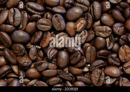 Makroaufnahme, Nahaufnahme von gerösteten Kaffeebohnen. Draufsicht, abstrakt, Hintergrund. Stockfoto