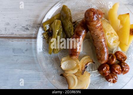 Nahaufnahme der spanischen Schweinswürste (butifarras) mit Kartoffeln, Zwiebeln und gerösteten Tomaten Stockfoto