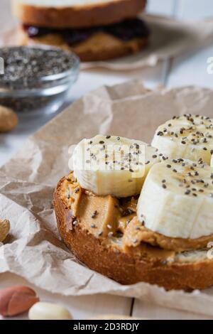 Fast Food, Snack, zwei Sandwiches mit Erdnussbutter-Marmelade und Bananen auf einem weißen Holztisch Stockfoto