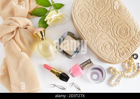 Kosmetik, Parfüms, Schmuck aus Perlen und Handtasche auf einem weißen Hintergrund. Flach, Ansicht von oben. Stockfoto