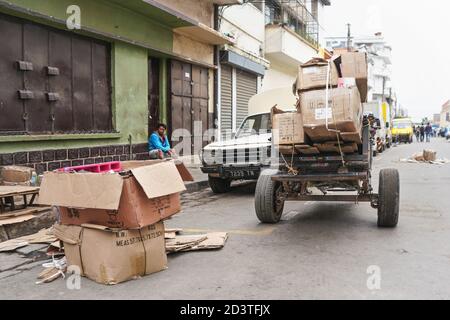 Antananarivo, Madagaskar - 24. April 2019: Einfacher Wagen mit leeren Kartons und Holzbrettern (zum Aufbau Stand für den Morgenmarkt) an der Hauptstr. Gezogen Stockfoto