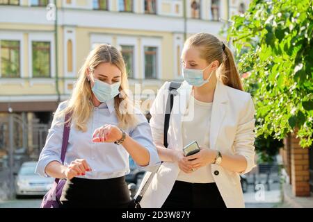 Büroangestellte zwei Frauen gehen, tragen medizinische Schutzmasken Stockfoto