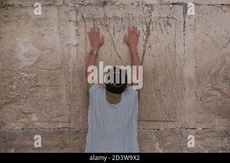 Ein religiöser Jude, der ein weißes Talit-Gewand trägt, das von religiösen Juden traditionell als Gebetstuch getragen wird, während er an der Westmauer in der Altstadt von Jerusalem in Israel betet Stockfoto