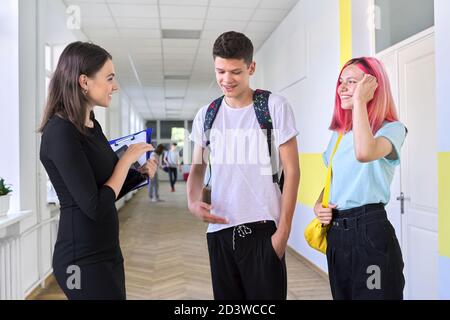 Gruppe von Jugendlichen Studenten im Gespräch mit einer Lehrerin in Schulflur Stockfoto