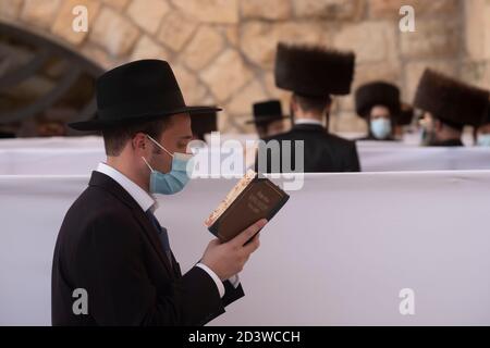 JERUSALEM, ISRAEL - OKTOBER 07: Haredi Juden aus der chassidischen Dynastie Rachmastrivka (benannt nach der Stadt Rotmistrivka in der Ukraine) tragen Schutzmaske, während sie in den Trennzellen für soziale Distanzierung während des Sukkot-Feiertages oder des Laubhüttenfestes an der Westmauer am 07. Oktober 2020 in Jerusalem, Israel, beten. Israel kämpft gegen einen der weltweit schlimmsten Coronavirus-Ausbrüche pro Kopf. Die ultra-orthodoxe Gemeinschaft, die etwa 12% der Bevölkerung ausmacht, macht mehr als ein Drittel der Coronavirus-Fälle des Landes aus. Stockfoto