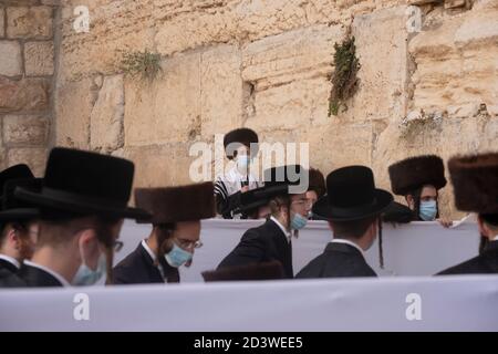 JERUSALEM, ISRAEL - OKTOBER 07: Haredi Juden aus der chassidischen Dynastie Rachmastrivka (benannt nach der Stadt Rotmistrivka in der Ukraine) tragen Schutzmaske, während sie in den Trennzellen für soziale Distanzierung während des Sukkot-Feiertages oder des Laubhüttenfestes an der Westmauer am 07. Oktober 2020 in Jerusalem, Israel, beten. Israel kämpft gegen einen der weltweit schlimmsten Coronavirus-Ausbrüche pro Kopf. Die ultra-orthodoxe Gemeinschaft, die etwa 12% der Bevölkerung ausmacht, macht mehr als ein Drittel der Coronavirus-Fälle des Landes aus. Stockfoto