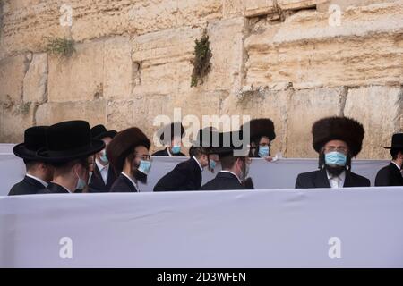 JERUSALEM, ISRAEL - OKTOBER 07: Haredi Juden aus der chassidischen Dynastie Rachmastrivka (benannt nach der Stadt Rotmistrivka in der Ukraine) tragen Schutzmaske, während sie in den Trennzellen für soziale Distanzierung während des Sukkot-Feiertages oder des Laubhüttenfestes an der Westmauer am 07. Oktober 2020 in Jerusalem, Israel, beten. Israel kämpft gegen einen der weltweit schlimmsten Coronavirus-Ausbrüche pro Kopf. Die ultra-orthodoxe Gemeinschaft, die etwa 12% der Bevölkerung ausmacht, macht mehr als ein Drittel der Coronavirus-Fälle des Landes aus. Stockfoto