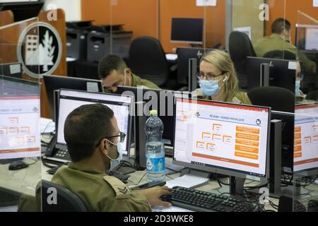 RAMLA, ISRAEL - 08. OKTOBER: Militärpersonal, das am 08. Oktober 2020 in der Nähe der Stadt Ramla in Israel epidemiologische Untersuchungen am Hauptquartier der israelischen Coronavirus-Task Force mit Computern durchgeführt hat. Das 'Alon' Coronavirus Command Center, das sich auf der Basis des Home Front Command befindet, unterstützt Gesundheitsbeamte bei Tests und epidemiologischen Untersuchungen von COVID-19-Patienten, um das Testverfahren zu verkürzen und die Infektionskette im Land zu verkürzen. Stockfoto