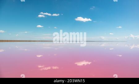 Lebendige rosa Salzsee Wasseroberfläche mit Spiegelreflexion von kleinen schönen Wolken mit blauem Himmel. Sywasch oder Sivash, das Putriden Meer oder Rotten Meer, Ukrain Stockfoto