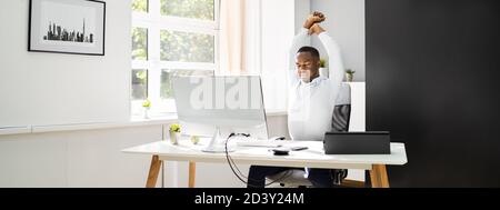 Büro Stretch-Übung Bei Der Arbeit. Afroamerikanischer Mann Stockfoto