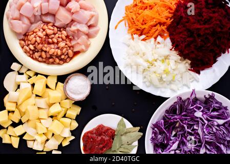Schritt-für-Schritt-Anleitung für die Vorbereitung einer Diät roten Borscht aus Hühnerfilet. Schritt zwei - in Scheiben geschnittene und geschälte Rohwaren, Kartoffeln, Bohnen, Tomaten Stockfoto