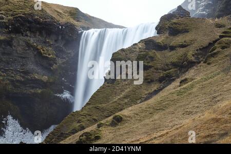 Skoga, ISLAND - Dec 10, 2018: Der Skoga Fluss fließt über den Rand einer Klippe, wodurch der Skogafoss Wasserfall entsteht, ein beliebter Wasserfall in Südisland Stockfoto