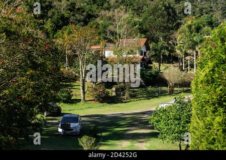 Der Parkplatz und Eingang der Brauerei Wolkenburg umgeben von grüner Vegetation und Wald der Region Cunha Landschaft. Stockfoto