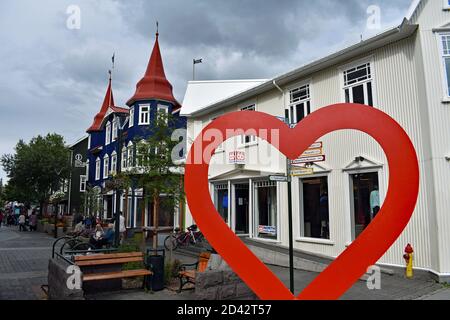 Hafnarstraeti Fußgängerzone im Stadtzentrum von Akureyri in Nordisland. Ein großes rotes Herz markiert den Eingang zur Straße. Stockfoto