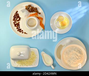 Mehl, Butter, zerbrochenes Ei, Milch, Zucker, Hefe, Salz, Backpulver, Rosinen, Nüsse, Orangenschale. Stockfoto
