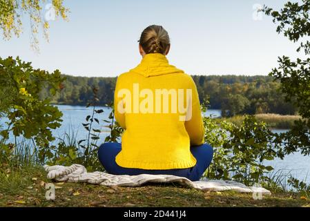 Schöne junge Mädchen meditieren im Herbst Park. Frau meditiert im Wald an sonnigen Tag. Stockfoto