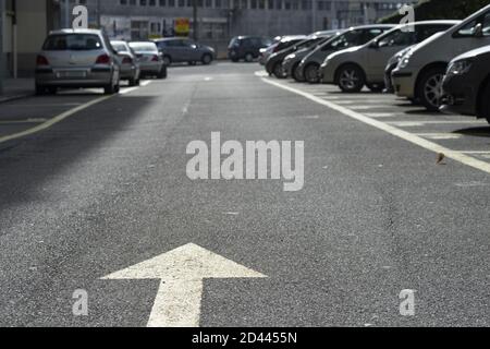 Pfeil Straßenschild (Markierung auf dem Boden) Mit großem Negativraum innerhalb des verschwommenen Hintergrunds Stockfoto