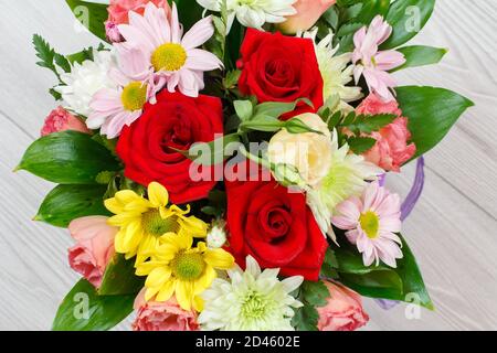 Großer Strauß von bunten verschiedenen Blumen auf dem grauen Holzhintergrund. Draufsicht. Stockfoto