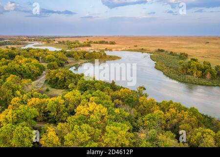 Flacher und breiter trostlos Fluss, der durch Nebraska Sandhills am Nebraska National Forest fließt, Luftaufnahme der Nachmittagslandschaft im frühen Herbst Stockfoto