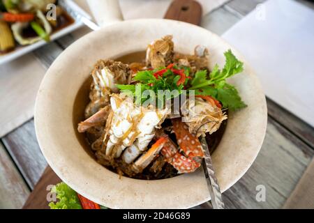 Gebackene blaue Krabbe mit Glasnudeln in einem Tontopf platziert, mit Koriander und Chili verziert. Sieht wunderschön aus, Blick von oben. Stockfoto