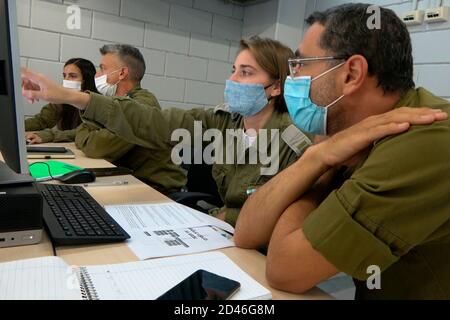 RAMLA, ISRAEL - 08. OKTOBER: Militärpersonal, das am 08. Oktober 2020 in der Nähe der Stadt Ramla in Israel epidemiologische Untersuchungen am Hauptquartier der israelischen Coronavirus-Task Force mit Computern durchgeführt hat. Das 'Alon' Coronavirus Command Center, das sich auf der Basis des Home Front Command befindet, unterstützt Gesundheitsbeamte bei Tests und epidemiologischen Untersuchungen von COVID-19-Patienten, um das Testverfahren zu verkürzen und die Infektionskette im Land zu verkürzen. Stockfoto