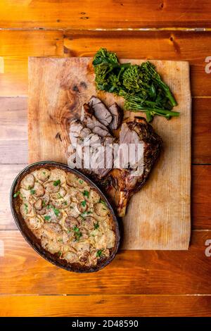 Rustikale gerötete Lammkeule und Dauphinoise-Kartoffeln Stockfoto