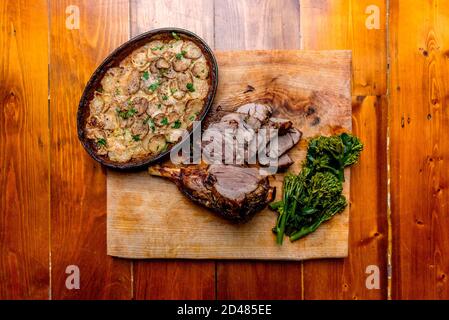 Rustikale gerötete Lammkeule und Dauphinoise-Kartoffeln Stockfoto