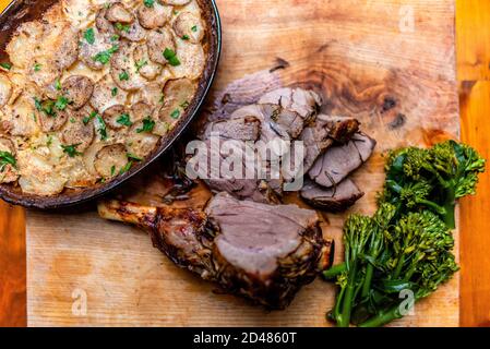 Rustikale gerötete Lammkeule und Dauphinoise-Kartoffeln Stockfoto