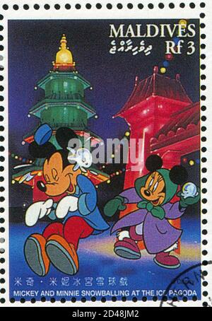 MALDIVE ISLANDS - UM 1996: Briefmarke gedruckt von Maldive Islands, zeigt Mickey, Minnie Schneeballing an der Eispagode, um 1996 Stockfoto