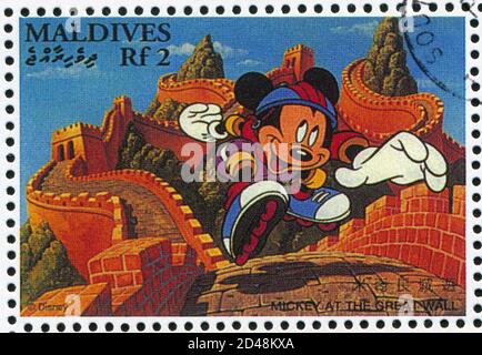 MALDIVE ISLANDS - UM 1996: Briefmarke gedruckt von Maldive Islands, zeigt Mickey an der Großen Mauer, um 1996 Stockfoto