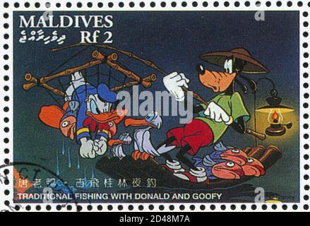 MALDIVE ISLANDS - UM 1996: Stempel gedruckt von Maldive Islands, zeigt traditionelles Fischen mit Donald, Goofy, um 1996 Stockfoto