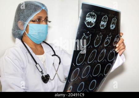 Indische Neurologen untersuchen eine Gehirn-CT-Scan-Platte bei Eine medizinische Klinik Stockfoto