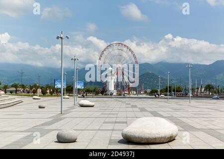 Batumi Georgia 25. Juni 2017: Riesenrad und alter Leuchtturm am Ufer in Batumi. Moderne Gebäude und touristische Entwicklung in Batumi, Georgien Stockfoto