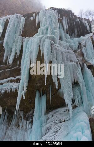 Atemberaubender gefrorener Wasserfall auf felsigen Bergklippen am Wintertag. Chegem, Republik Kabardino-Balkarien, Russland Stockfoto