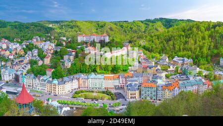 Karlovy Vary Stadt Luftpanorama mit Reihe von bunten bunten bunten Gebäuden und Spa-Hotels im historischen Stadtzentrum. Panorama von Karlsbad Stadt und Slavkov Wald Berge, Tschechische Republik Stockfoto