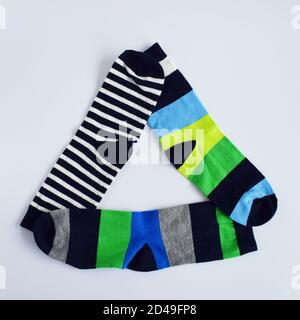 Dreieck von bunten Socken auf reinem weißen Hintergrund. Stockfoto