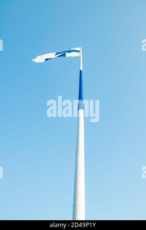 Die größte finnische Flagge der Welt und der höchste Fahnenmast in Europa gegen blauen Himmel, Hamina, Finnland. Der Fahnenmast ist 100 Meter hoch. Stockfoto