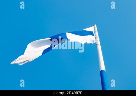 Die größte finnische Flagge der Welt und der höchste Fahnenmast in Europa gegen blauen Himmel, Hamina, Finnland. Der Fahnenmast ist 100 Meter hoch. Stockfoto