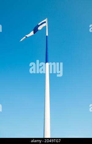 Die größte finnische Flagge der Welt und der höchste Fahnenmast in Europa gegen blauen Himmel, Hamina, Finnland. Der Fahnenmast ist 100 Meter hoch. Stockfoto