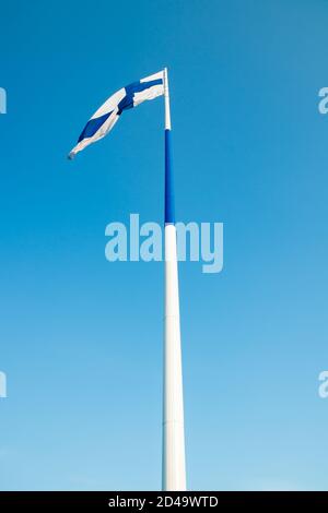 Die größte finnische Flagge der Welt und der höchste Fahnenmast in Europa gegen blauen Himmel, Hamina, Finnland. Der Fahnenmast ist 100 Meter hoch. Stockfoto