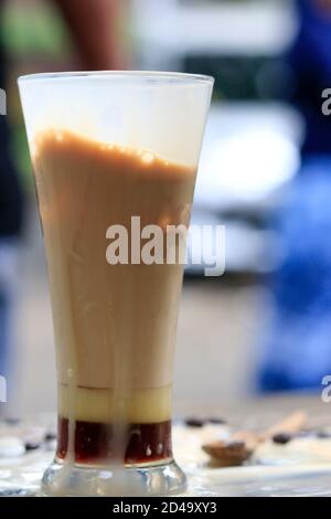 Eine Tasse Eismilchkaffee auf einem hölzernen Kaffeetisch. Brauen Sie frischen Kaffee für Kaffeepausen während des Tages Stockfoto