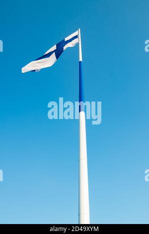 Die größte finnische Flagge der Welt und der höchste Fahnenmast in Europa gegen blauen Himmel, Hamina, Finnland. Der Fahnenmast ist 100 Meter hoch. Stockfoto