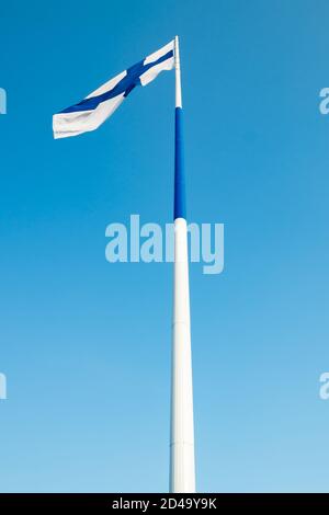 Die größte finnische Flagge der Welt und der höchste Fahnenmast in Europa gegen blauen Himmel, Hamina, Finnland. Der Fahnenmast ist 100 Meter hoch. Stockfoto