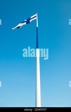 Die größte finnische Flagge der Welt und der höchste Fahnenmast in Europa gegen blauen Himmel, Hamina, Finnland. Der Fahnenmast ist 100 Meter hoch. Stockfoto