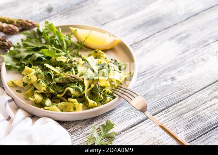 Tagliatelle mit Spinat und Spargel. Pasta mit Sahne-Sauce und Gemüse Stockfoto