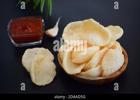 Frisches Krurupuk auf dunklem Hintergrund.Garnelencracker oder Garnelen Chips mit Ketchup und Knoblauch Stockfoto