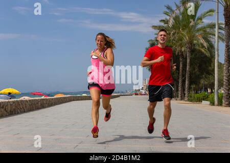 Paar Joggen draußen auf der Strandpromenade in der Nähe des Meeres.Athletic Paar Konzept .Sport und gesunde Lifestyle-Idee. Stockfoto